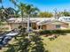 Well-maintained home featuring a lush lawn, mature trees, a two-car garage and tropical landscaping at 5630 Saint Louis Ave, Sarasota, FL 34233