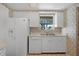 Functional kitchen featuring white appliances, a window view, and classic cabinetry at 5630 Saint Louis Ave, Sarasota, FL 34233