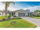 Newly built home with gray garage door, landscaping, and paved driveway at 5866 Bungalow Grove Ct, Palmetto, FL 34221