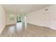 Bright living room with wood-look tile floors and sliding glass doors at 5866 Bungalow Grove Ct, Palmetto, FL 34221