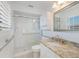 Bathroom featuring a glass enclosed shower, granite countertop, and natural light at 627 Dundee Ln, Holmes Beach, FL 34217