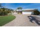 Single-story home with attached garage, white roof, and a circular driveway at 627 Dundee Ln, Holmes Beach, FL 34217