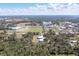 Aerial view of a property with two buildings surrounded by lush trees and manicured sports fields at 6521 121 St E Ave, Parrish, FL 34219