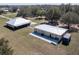 Aerial view of two metal roofed residential buildings on a sprawling property with mature trees at 6521 121 St E Ave, Parrish, FL 34219