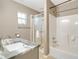 Neutral toned bathroom featuring a single vanity, and a shower-tub combo with a glass door at 6521 121 St E Ave, Parrish, FL 34219