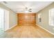 Large bedroom showcasing wood floors, a feature wall, and natural light from a window at 6521 121 St E Ave, Parrish, FL 34219