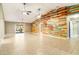 Spacious living room featuring a wood plank wall, ceiling fans, and tile flooring at 6521 121 St E Ave, Parrish, FL 34219