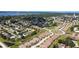 Aerial view of a residential neighborhood with lush landscaping, winding streets, and a glimpse of the bay at 6912 Playa Bella Dr, Bradenton, FL 34209