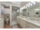 Bright bathroom featuring double vanity sinks, a glass shower, and an adjacent toilet room at 6912 Playa Bella Dr, Bradenton, FL 34209