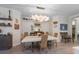 Inviting dining area with a modern chandelier and seating for six, adjacent to open shelving at 6912 Playa Bella Dr, Bradenton, FL 34209