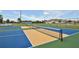 Community tennis court with vibrant blue and gold surface, ready for a friendly match under a sunny sky at 6912 Playa Bella Dr, Bradenton, FL 34209