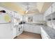 Galley kitchen with white cabinets and granite countertops at 7 Quails Run Blvd # 9, Englewood, FL 34223