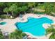 Aerial view of the luxurious community pool with ample seating, umbrellas, and lush landscaping at 7103 Westhill Ct, Lakewood Ranch, FL 34202