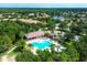 Expansive aerial view of the community pool with abundant seating and pavilion, nestled among lush trees and homes at 7103 Westhill Ct, Lakewood Ranch, FL 34202