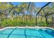 A screened-in pool is surrounded by lush greenery, providing privacy and a tranquil atmosphere at 7103 Westhill Ct, Lakewood Ranch, FL 34202