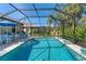 A beautiful screened-in pool with lounge chairs and tables sits among green backyard landscaping at 7103 Westhill Ct, Lakewood Ranch, FL 34202