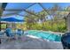 Inviting screened-in pool area with a dining set and lush landscaping at 7103 Westhill Ct, Lakewood Ranch, FL 34202