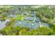 Aerial view highlighting the tennis facilities surrounded by mature trees and greenery at 7327 Kensington Ct, University Park, FL 34201