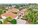 Aerial view showcasing the home's tile roof, lush landscaping, and proximity to the water at 7327 Kensington Ct, University Park, FL 34201