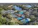 An aerial view showcasing tennis and pickleball courts nestled among trees, near a scenic lake, and community at 7327 Kensington Ct, University Park, FL 34201