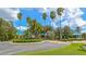 Community clubhouse with mature landscaping, a circular driveway, and palm trees on a sunny day at 7327 Kensington Ct, University Park, FL 34201