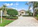 Beautiful home exterior featuring a well-manicured lawn and a brick driveway at 7327 Kensington Ct, University Park, FL 34201