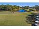 Golf course scene with players on the green, a water hazard, and several golf carts parked nearby at 7327 Kensington Ct, University Park, FL 34201