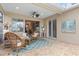 Inviting covered patio with wicker furniture, ceiling fan, and a view of the outdoor artwork and wall decor at 7327 Kensington Ct, University Park, FL 34201