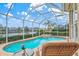 Relaxing backyard oasis featuring a pool, spa, screened enclosure, and serene lake views at 7327 Kensington Ct, University Park, FL 34201