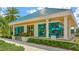 Exterior of the golf course Pro Shop featuring large windows, a blue roof, and manicured landscaping at 7327 Kensington Ct, University Park, FL 34201