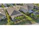 Aerial view of a house with a pool and screened enclosure, surrounded by lush landscaping at 7812 Birdie Bend Way, Sarasota, FL 34241