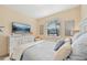 Bright bedroom with a queen-size bed, dresser, and window at 7812 Birdie Bend Way, Sarasota, FL 34241