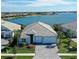 Single-Gathering home with a lake view, gray roof, and two-car garage at 8063 Waterbend Trl, Sarasota, FL 34240