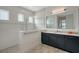 Modern bathroom with walk-in shower, gray cabinets, and a large mirror at 8063 Waterbend Trl, Sarasota, FL 34240