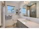 Clean bathroom with gray vanity, shower, and window at 8063 Waterbend Trl, Sarasota, FL 34240