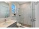 Modern bathroom with gray vanity, frameless shower, and window at 8063 Waterbend Trl, Sarasota, FL 34240