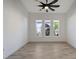 Bright bedroom featuring wood-look floors and three windows at 8063 Waterbend Trl, Sarasota, FL 34240