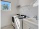 Bright laundry room features washer, dryer, and utility sink at 8063 Waterbend Trl, Sarasota, FL 34240