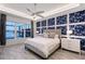 Main bedroom with water views, geometric wall, and large bed at 8063 Waterbend Trl, Sarasota, FL 34240