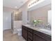 Bathroom featuring a toilet, walk-in shower and double granite vanity at 8362 Enclave Way # 103, Sarasota, FL 34243