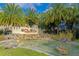 Community entrance sign with water feature and lush landscaping with palm trees on a sunny day at 8362 Enclave Way # 103, Sarasota, FL 34243