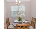 Breakfast nook has a modern light fixture and a floral centerpiece on the dining table at 8362 Enclave Way # 103, Sarasota, FL 34243