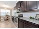 Stylish kitchen with dark cabinets, granite counters, stainless steel appliances, and a charming breakfast nook at 8362 Enclave Way # 103, Sarasota, FL 34243