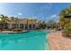 Community pool area with lounge chairs and well-maintained landscaping at 8362 Enclave Way # 103, Sarasota, FL 34243