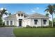 Two-story home with white exterior, gray roof, and palm trees at 8508 Sandpoint St, Sarasota, FL 34240