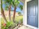 Gray front door entrance with landscaping and palm trees at 9918 50Th Street E Cir, Parrish, FL 34219