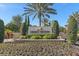 Legacy Estates entrance sign with well-maintained landscaping, vibrant flowers and palm trees in the foreground at 12410 Osorio Ct # 201, Sarasota, FL 34238