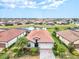 Stunning aerial view of a beautiful home with tile roof, surrounded by lush landscaping and serene pond at 12675 Richezza Dr, Venice, FL 34293