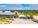 Aerial view showcases the beach restaurant, sandy shore, palm trees and oceanfront dining experience at 12675 Richezza Dr, Venice, FL 34293