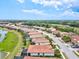 Beautiful aerial view of a neighborhood with tile roofs and a scenic pond at 12675 Richezza Dr, Venice, FL 34293